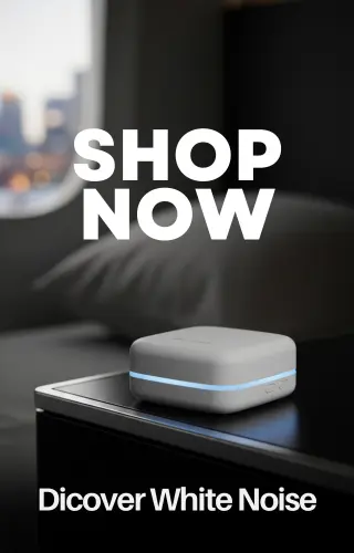 Portable white noise machine on nightstand next to a travel bag